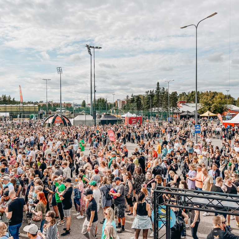 Huge group of people standing at festival area outdoor during summer