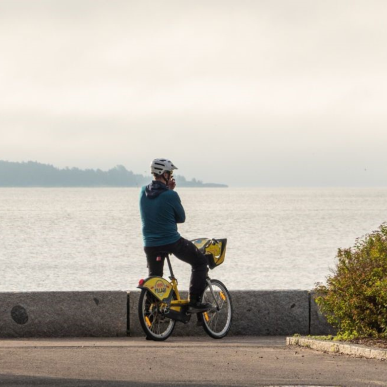 Man standing still on citybike and watching over the sea