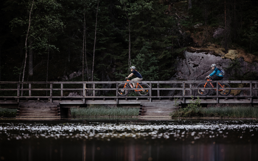 Two cyclists on the path next to lake in Nuuksio National Park