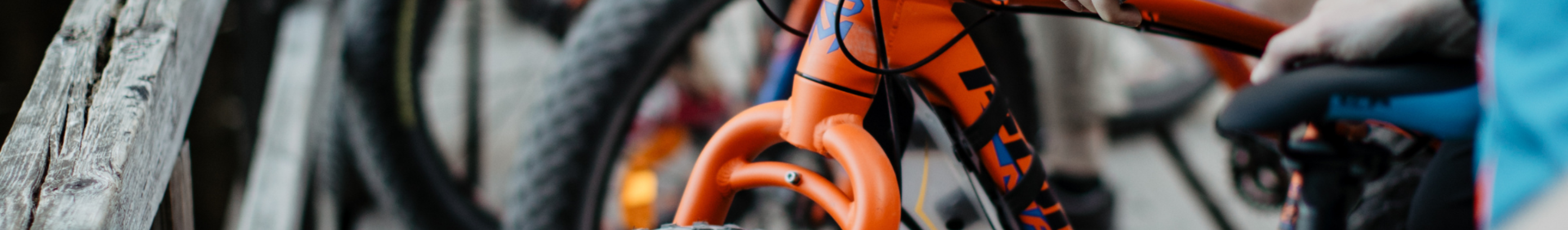 Orange bikes next to each other and human hands holding them