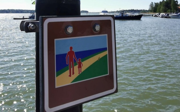 Signpost of the Espoo Waterfront Walkway with the Baltic Sea in background