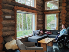 Wheelchair visitor inside log cabin from Hawkhill Cottage Resort