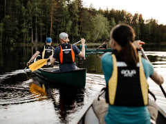 Group canoeing during summer on lake in Nuuksio National Park