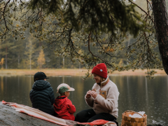 Woman with children having outdoor picnic in forest